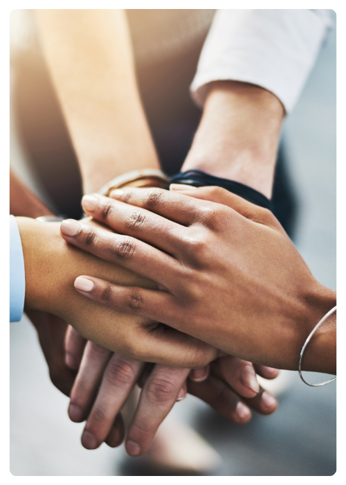 Hands of different ethnicities stacked on top of one another showing commitment.