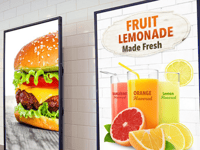 Digital displays in a restaurant showing a burger and lemonade