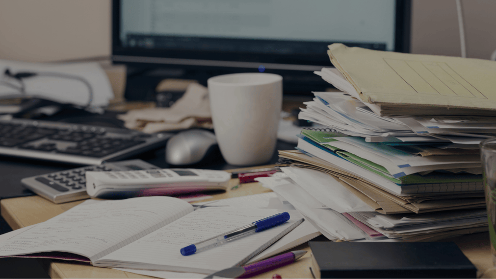 A messy office desk covered in papers.