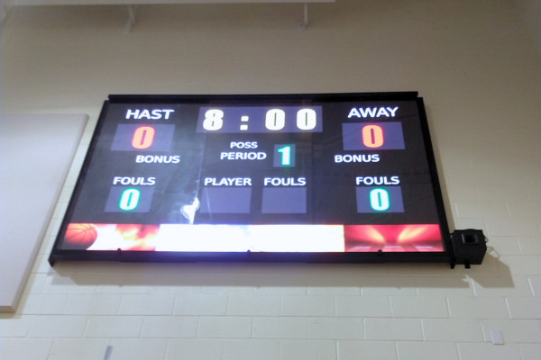 A digital scoreboard in a high school gym.