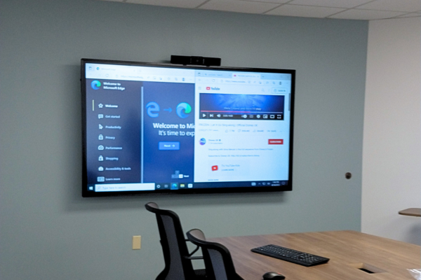 A professional display with a webcam in a conference room.