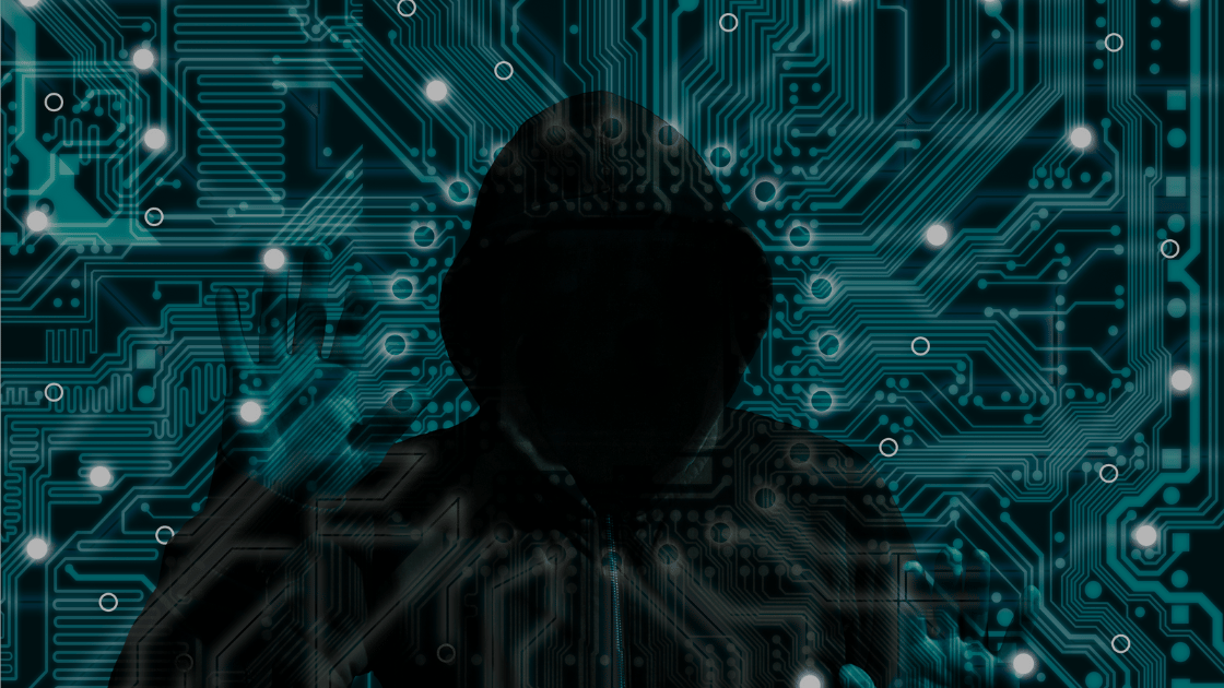 A cyber hacker in a hoodie with light blue digital graphics around their face.