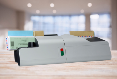 A piece of mailing equipment sitting on a wooden table in an office.