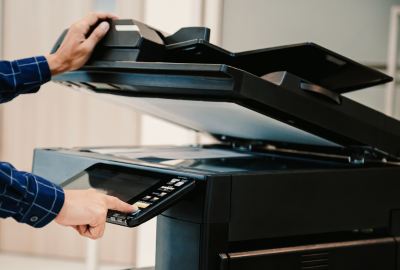 A person making a copier on a multifunctional printer.