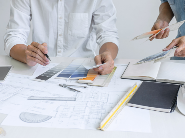 Two people looking at room drawings with swatches of colors.