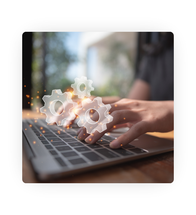 An image of a person working on a laptop at their desk and digital-looking gears super-imposed over the top.