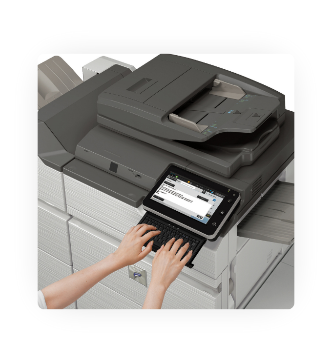 A person typing on a keyboard that is part of a Sharp multifunctional printer.