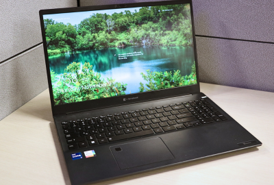 An open laptop sitting on a desk with a green and blue landscape background